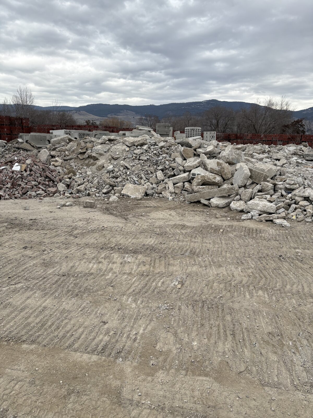 Large stockpile of aggregate material under cloudy sky